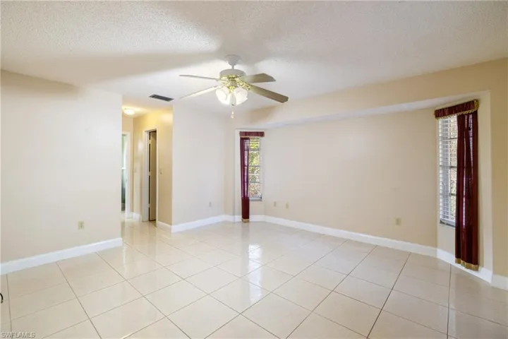 Unfurnished room featuring light tile patterned floors, a textured ceiling, and ceiling fan