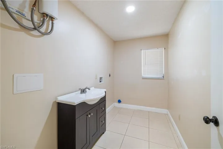 Bathroom featuring tile patterned floors, vanity, and a textured ceiling