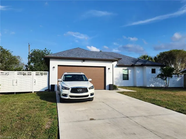 View of front of house featuring a garage and a front lawn