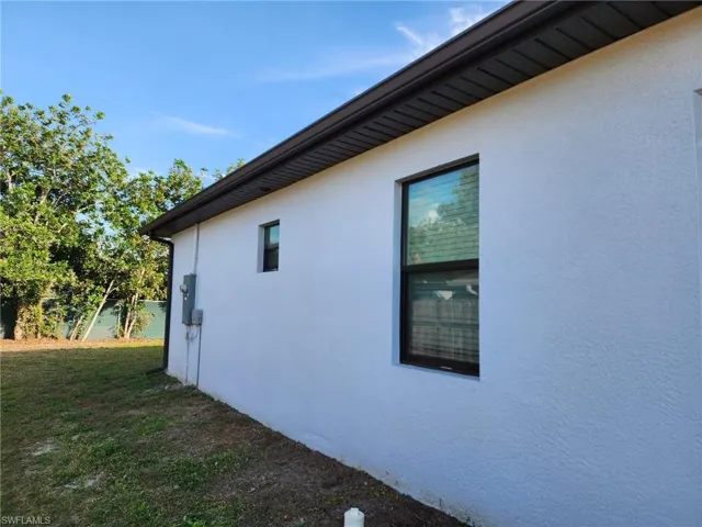 View of side of property featuring a lawn