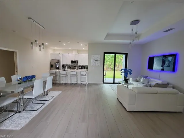 Living room featuring a raised ceiling and light wood-type flooring