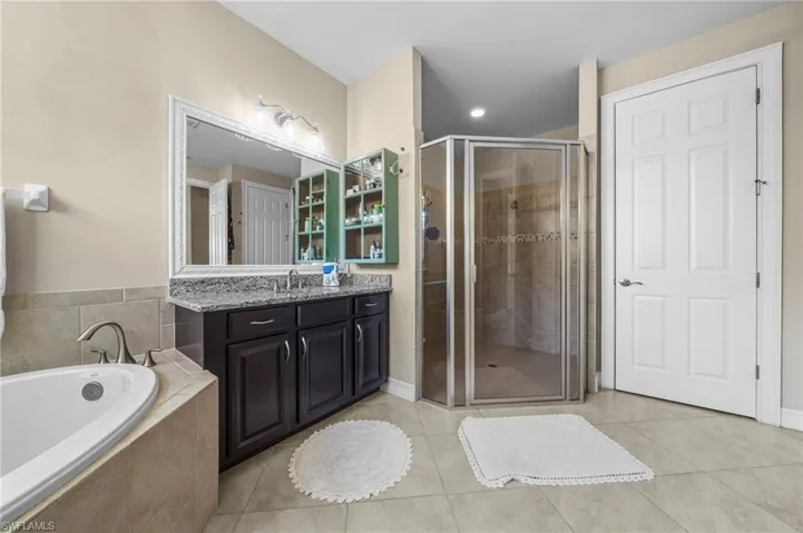Bathroom featuring a bath, light tile patterned floors, vanity, a shower stall, and recessed lighting
