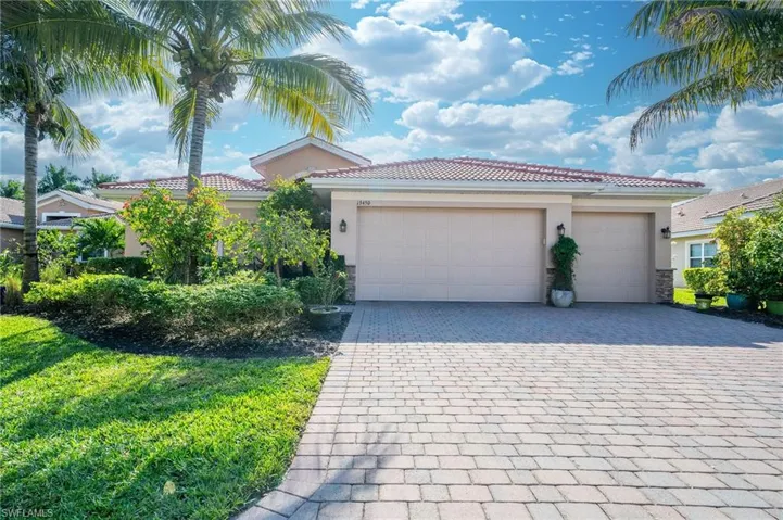 View of front of house featuring stucco siding, decorative driveway, a tiled roof, stone siding, and a garage
