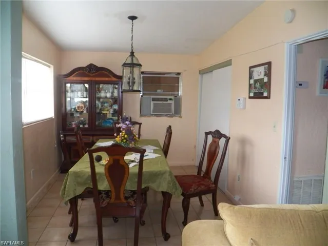 Dining room featuring cooling unit and tile patterned floors