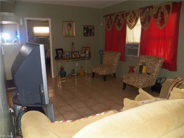 Living room featuring cooling unit and tile patterned flooring