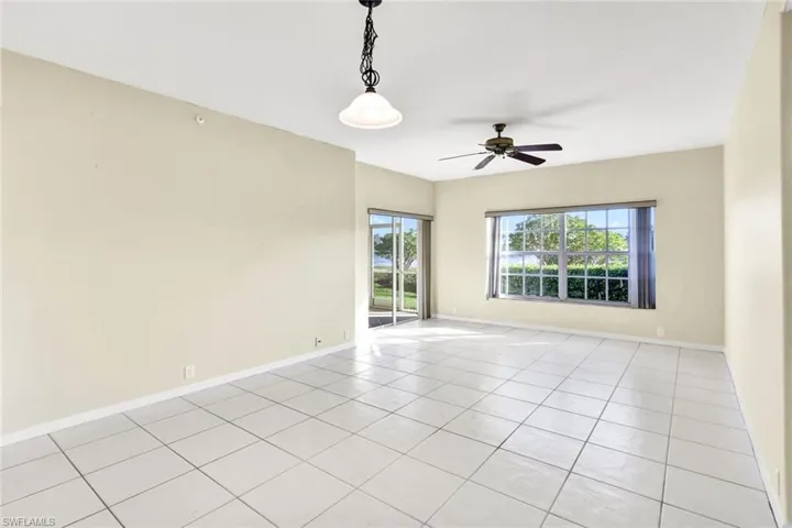 Tiled spare room featuring ceiling fan