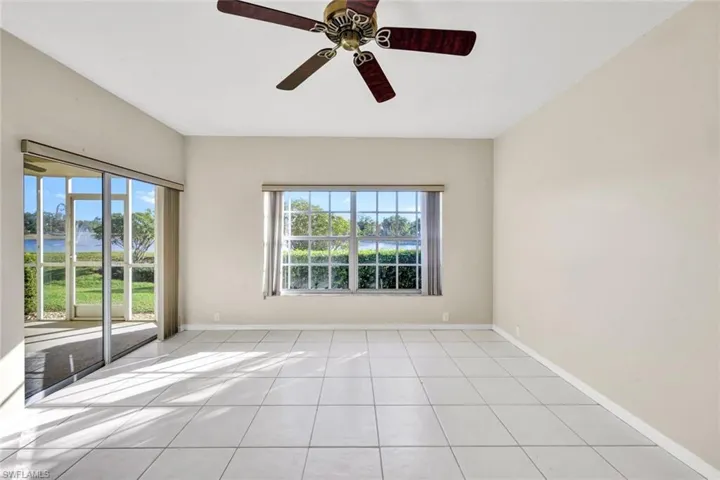 Tiled empty room featuring a wealth of natural light and ceiling fan