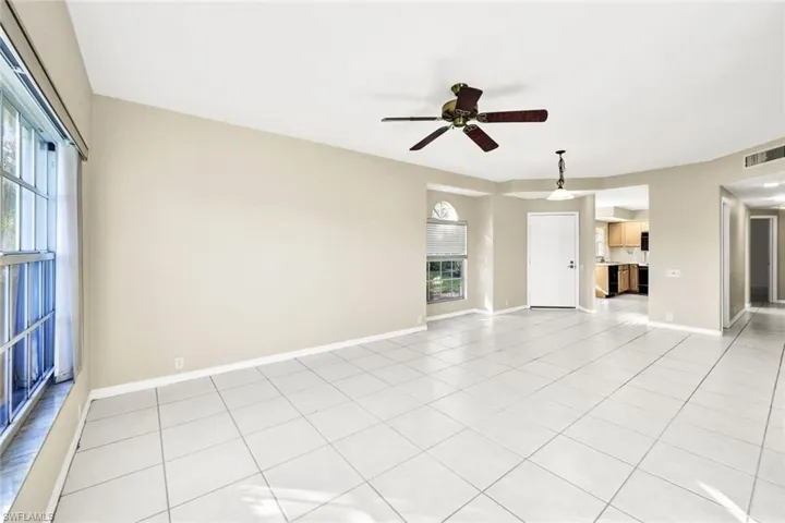 Unfurnished living room with ceiling fan and light tile patterned flooring