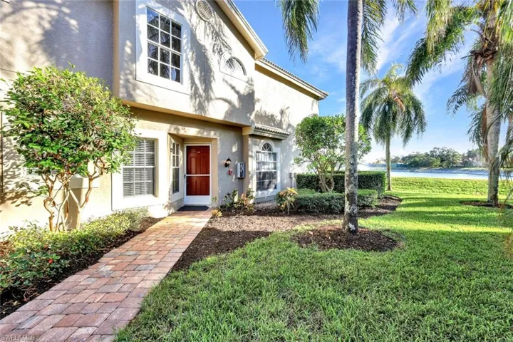 Doorway to property featuring a lawn and a water view