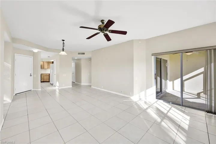 Unfurnished living room with ceiling fan and light tile patterned floors