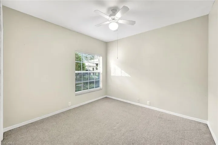Spare room featuring carpet flooring and ceiling fan