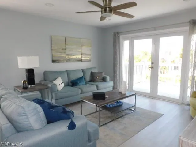 Living room featuring wood finished floors, ceiling fan, and french doors