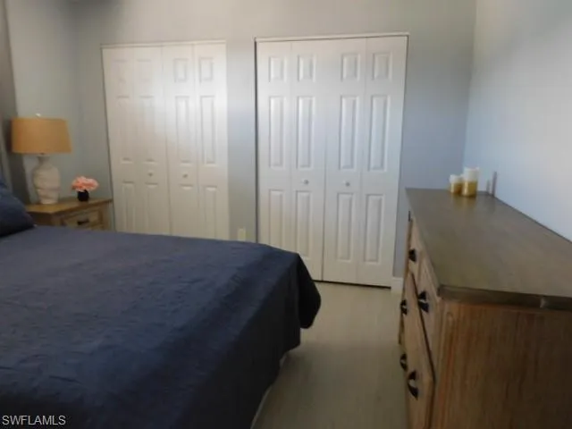 Bedroom featuring multiple closets and light wood finished floors