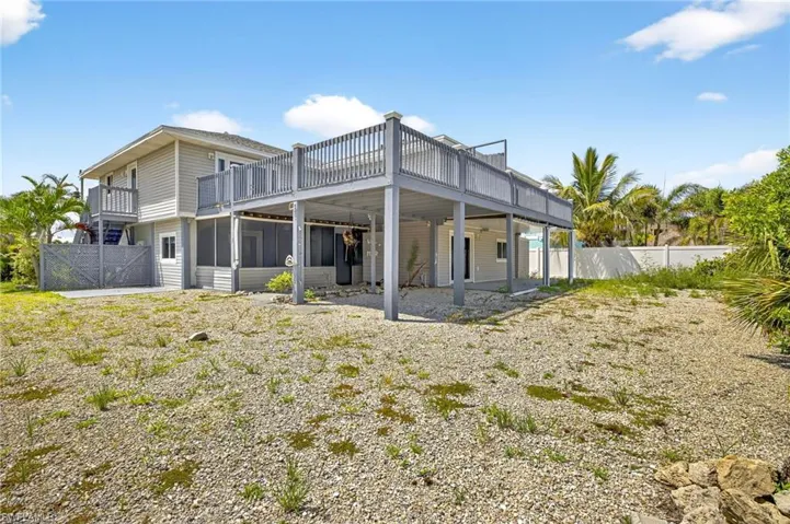 Back of property featuring a sunroom and a balcony