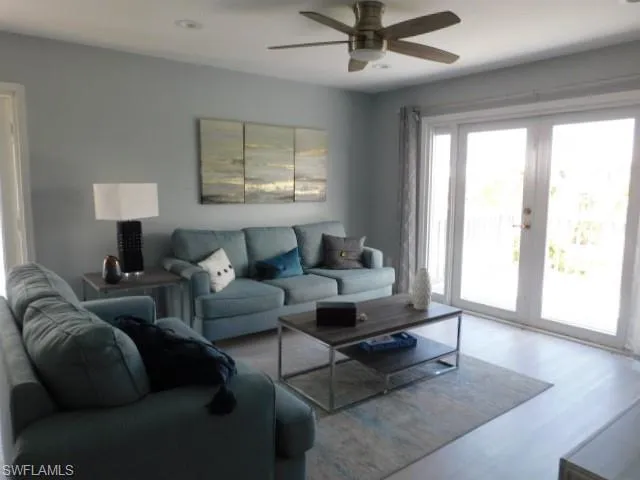 Living area with french doors, ceiling fan, and wood finished floors