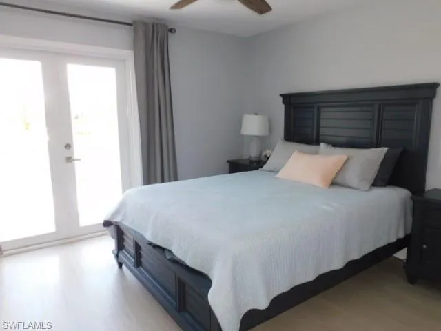Bedroom featuring light wood-type flooring, multiple windows, french doors, and ceiling fan