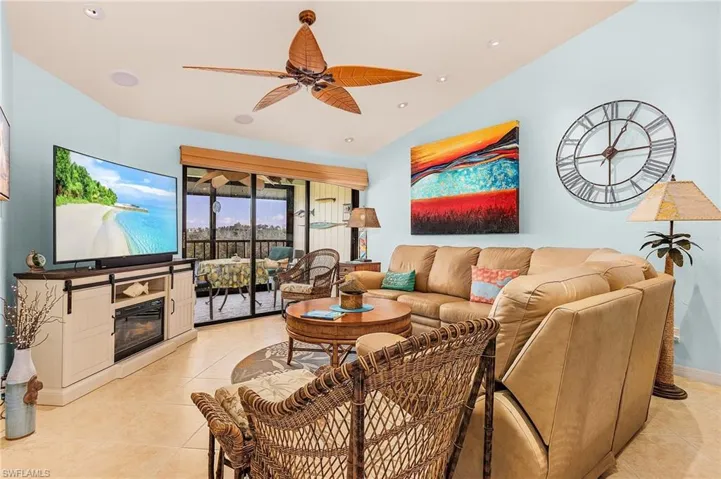 Living room with ceiling fan and light tile floors