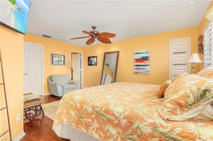Bedroom with dark hardwood / wood-style floors and ceiling fan