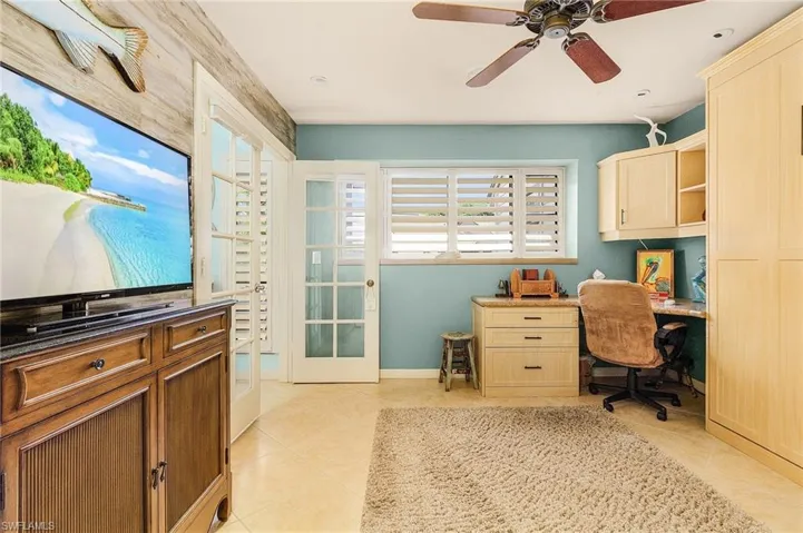 Office area with ceiling fan, french doors, and light tile floors