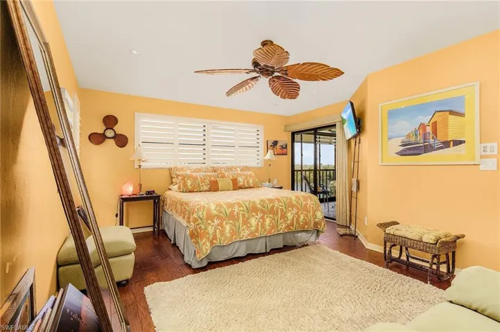 Bedroom featuring access to outside, dark wood-type flooring, and ceiling fan