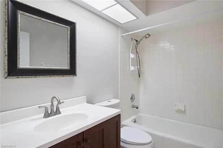 Full bathroom with toilet, vanity, and shower / washtub combination