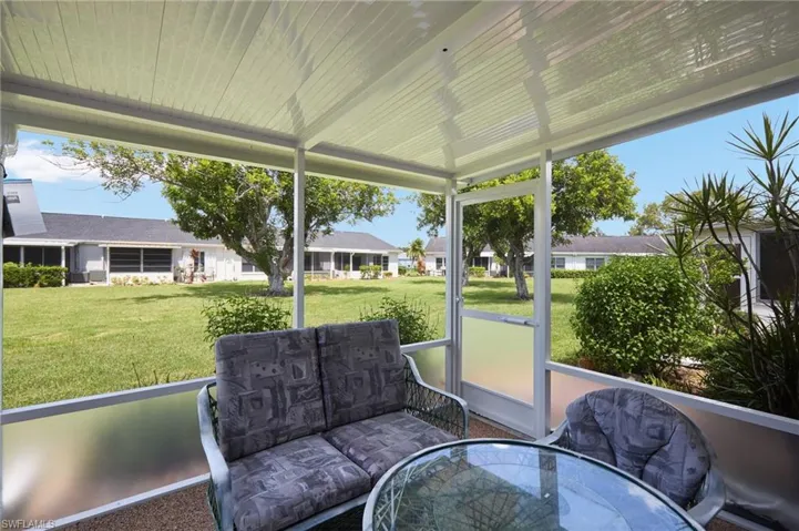 Sunroom with outdoor dining space and a residential view