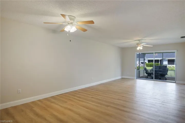 Spare room featuring ceiling fan, a textured ceiling, light wood-style flooring, and baseboards
