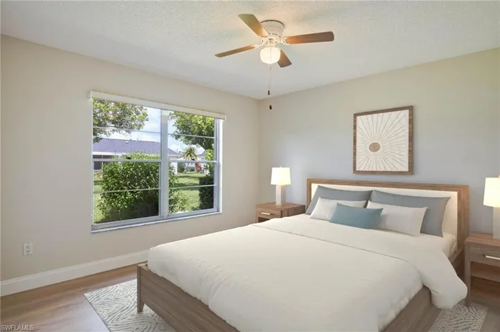 Bedroom featuring wood finished floors, baseboards, a textured ceiling, and a ceiling fan