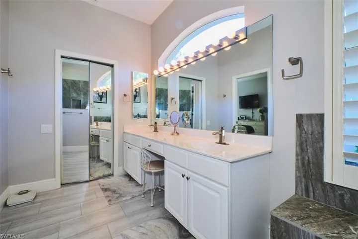 Full bath featuring double vanity and baseboards