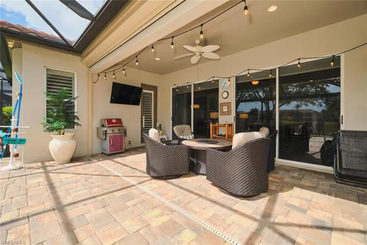 View of patio with a ceiling fan, a lanai, and area for grilling