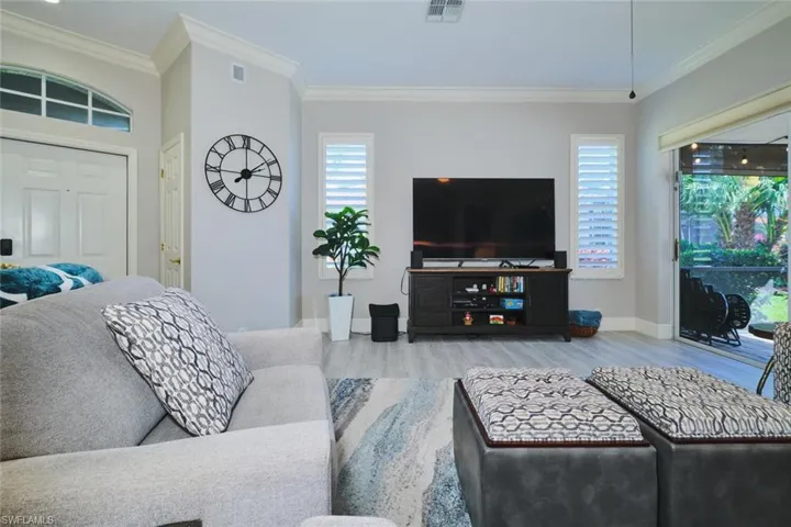 Living area featuring crown molding and light wood-type flooring