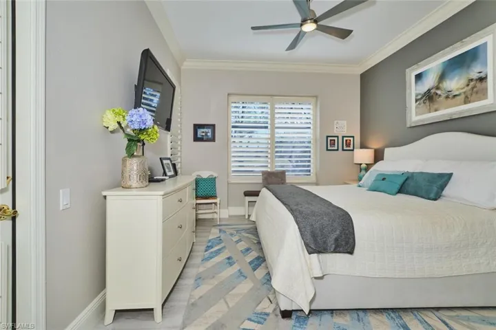 Bedroom with ornamental molding, ceiling fan, and light wood finished floors