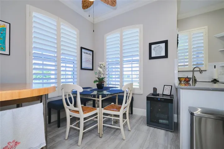 Dining room featuring wine cooler, crown molding, and a ceiling fan