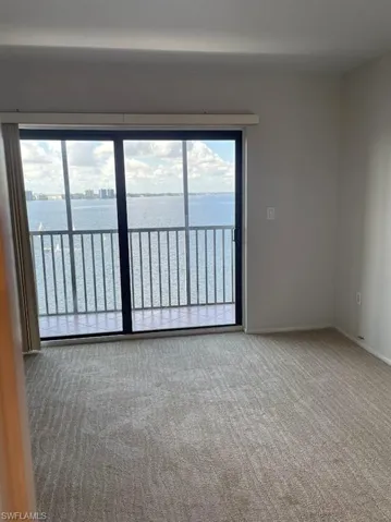 Carpeted spare room with a water view and baseboards