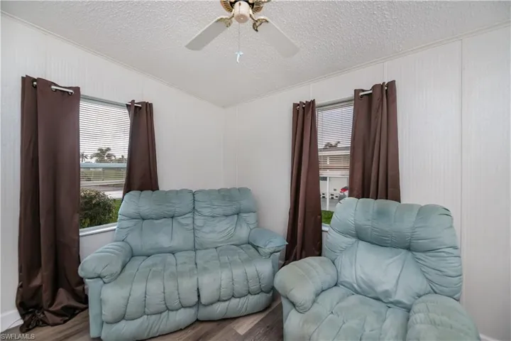 The den off the living area features a vaulted ceiling, ceiling fan and ornamental molding