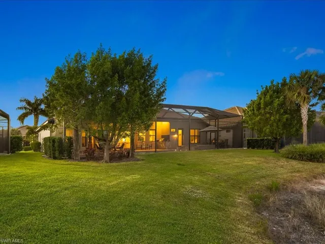 Back of property with a lawn and glass enclosure