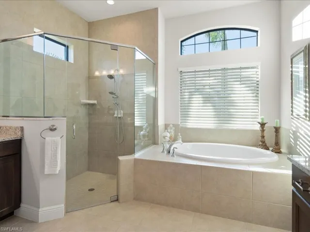 Bathroom featuring separate shower and tub, tile patterned floors, vanity, and a healthy amount of sunlight