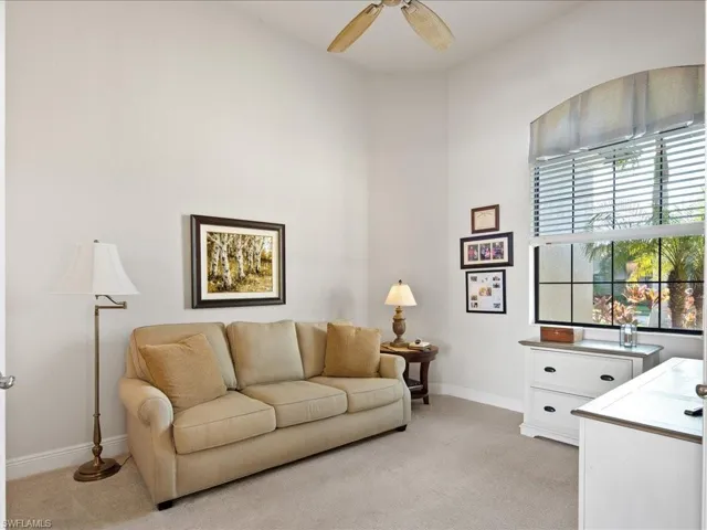 Living room with light colored carpet and ceiling fan