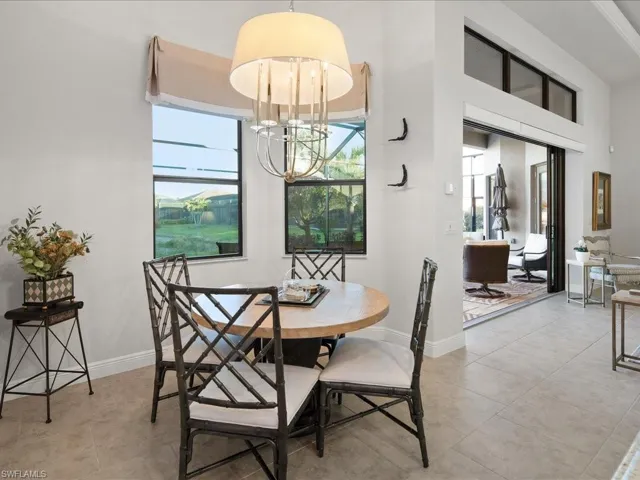 Dining room with light tile patterned flooring and an inviting chandelier