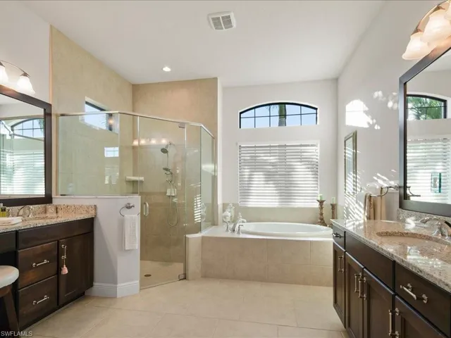 Bathroom with tile patterned flooring, vanity, and plus walk in shower