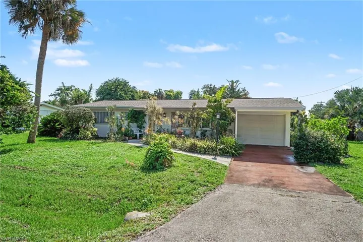 Ranch-style exterior with an attached garage, featuring a paved driveway and a front walkway
