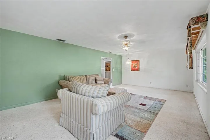 Spacious interior featuring a recessed ceiling light fixture, a wide window, and a light-colored carpeted floor