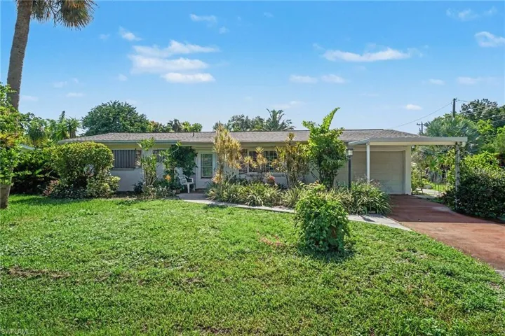Exterior residence with a covered carport, attached garage, and a concrete driveway