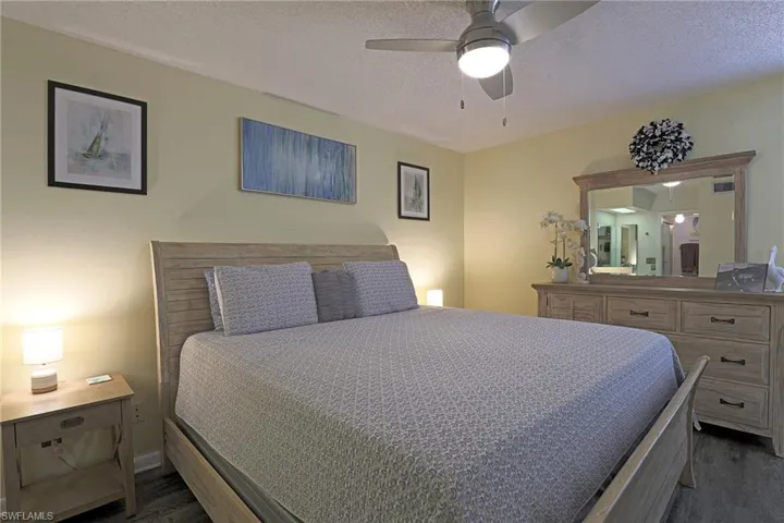 Bedroom featuring wood-finish flooring, a ceiling fan with integrated lighting, and light-toned walls