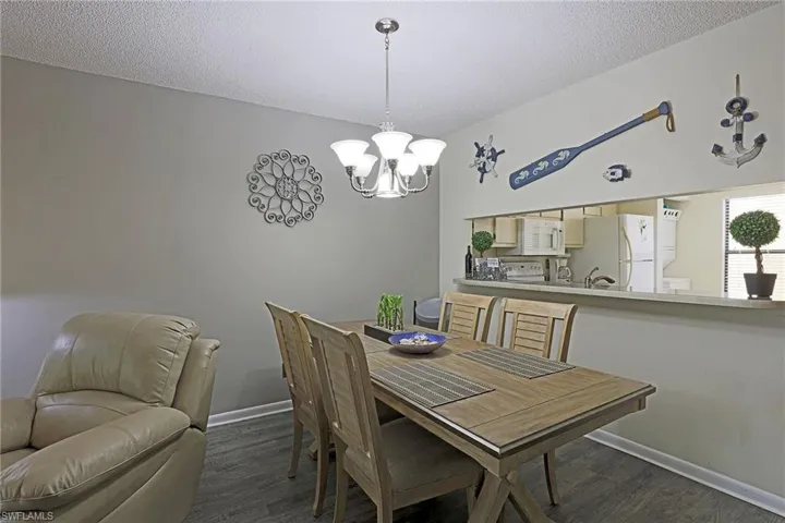 Dining area featuring wood-finish flooring and a contemporary chandelier