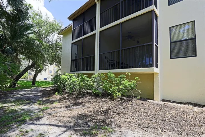 Exterior featuring screened balconies, stucco siding, and dark-framed windows