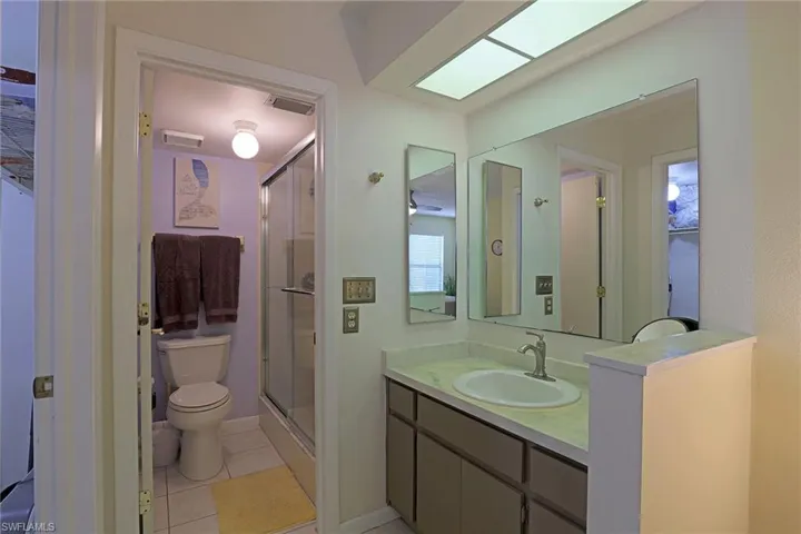 Bathroom vanity featuring an integrated sink, brushed nickel faucet, and a large wall-mounted mirror