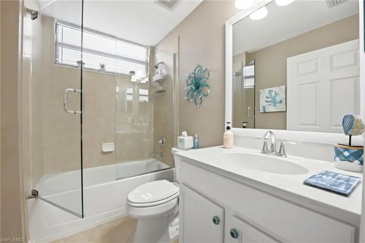 Guest bath with frameless glass doors and white cabinets
