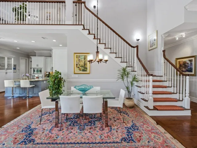 Dining room featuring ornamental molding, dark wood finished floors, a high ceiling, and a chandelier