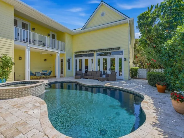Rear view of property with a patio area, a balcony, a pool with connected hot tub, and outdoor lounge area